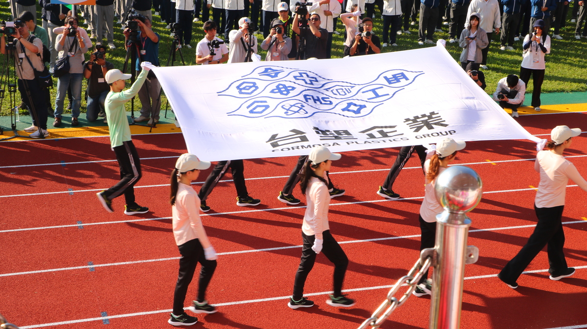 8名明志科技大學同學高舉會旗自司令台左方進入圖片